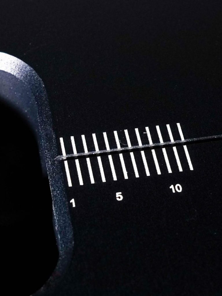 Aluminium eloxiert schwarz – hoher Kontrast mit weißer Schrift Bild eines Bauteiles. Aluminium eloxiert schwarz – hoher Kontrast mit weißer Schrift